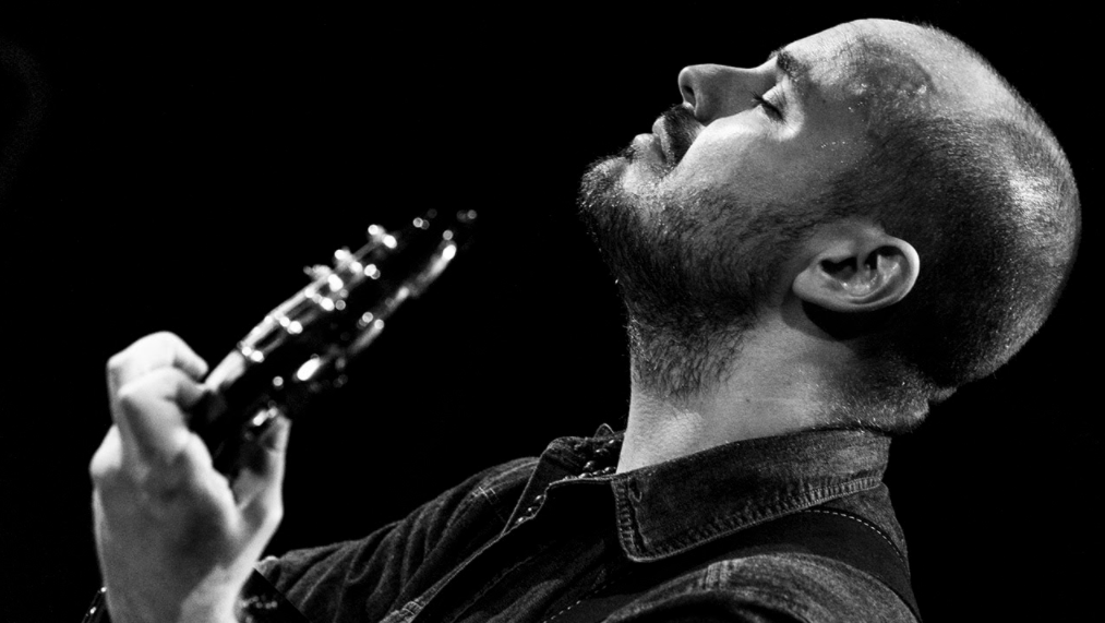 Photo courtesy of Andy McKee black and white photo of Andy McKee playing on stage with eyes closed
