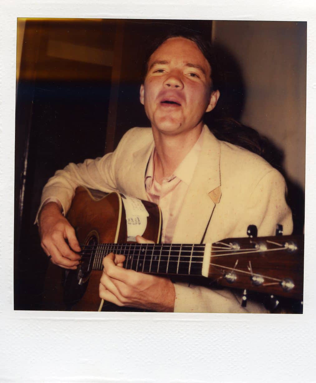 Polaroid of Michael singing and playing guitar