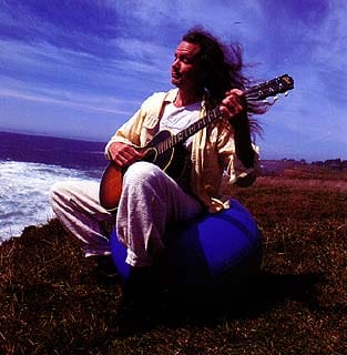 Michael playing guitar by the ocean